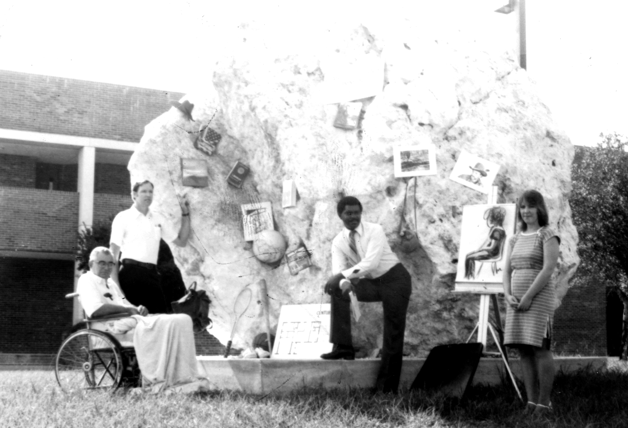 Faculty and students pose in front of first artwork of the North Campus sculptured rock that sits outside the main entryway in Brooksville, Fla.