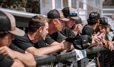 ball players leaning at fence