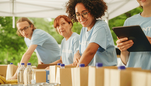 Group of female volunteers packing water and food bags.