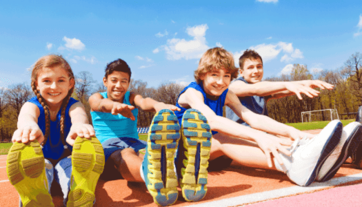 Group of 4 kids stretching on the track field