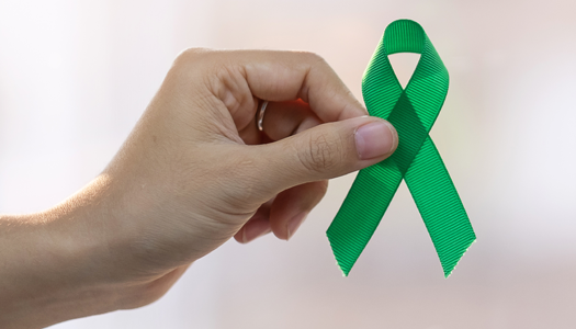 hand holding a green ribbon