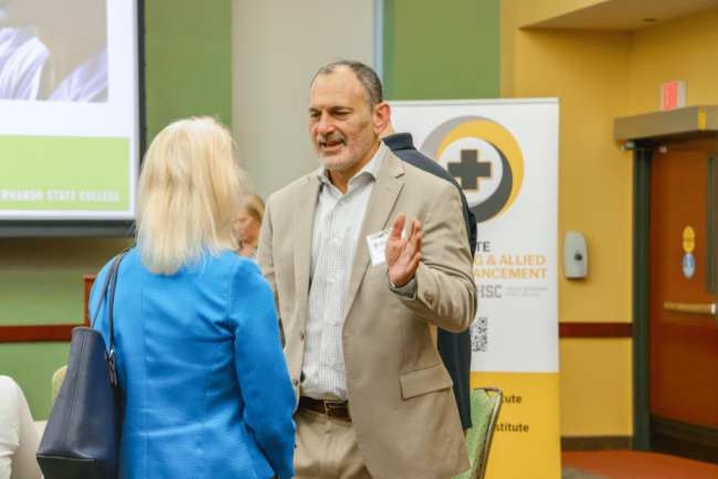 Joseph Resnick, Premier Community HealthCare Group, president and CEO, in discussion during the quarterly meeting reception