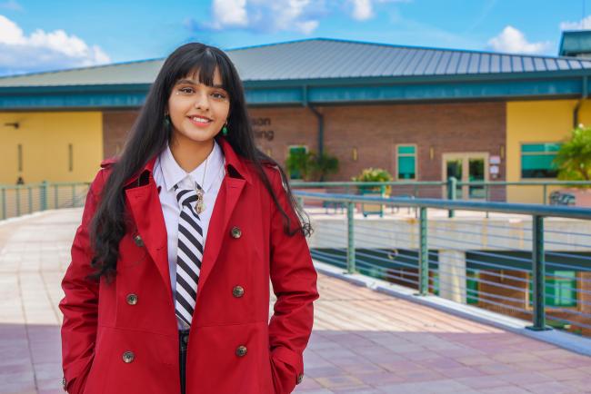 Headshot of Iman Bhyat standing outside of a building.