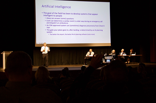 An image of Larence Hall Ph.D giving a speech on AI and Business.