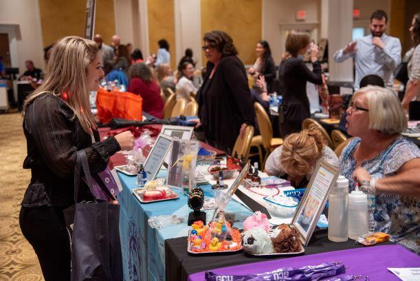 Student conversing with a Student Life Retreat vendor during the expo
