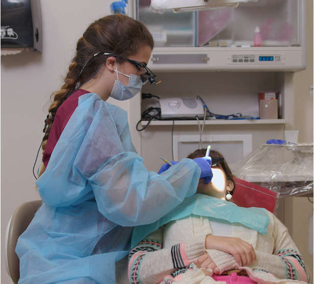 dental hygiene student working on dental patient in chair